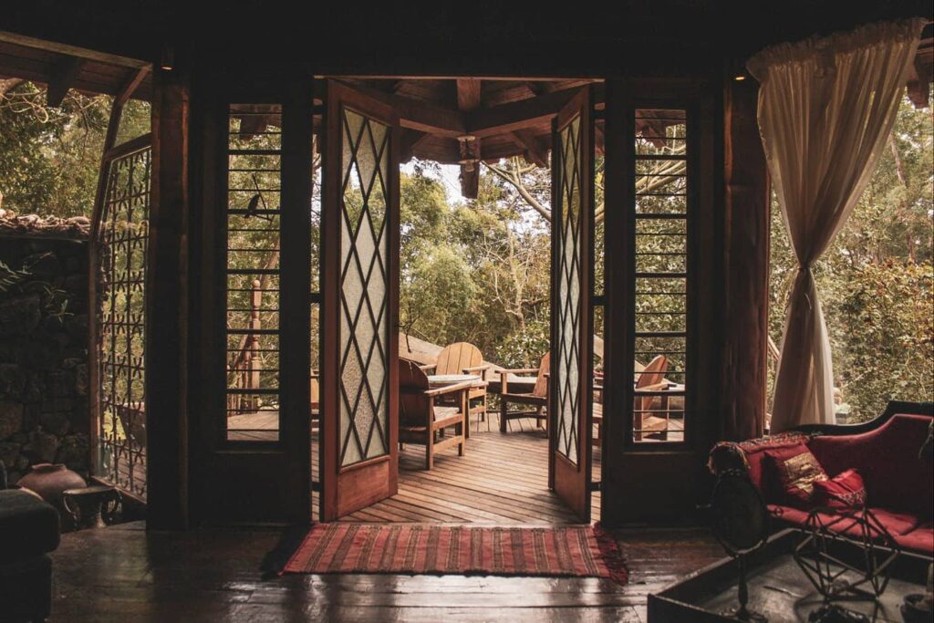 Terraço do Airbnb visto da sala, com mesas e cadeiras de madeira