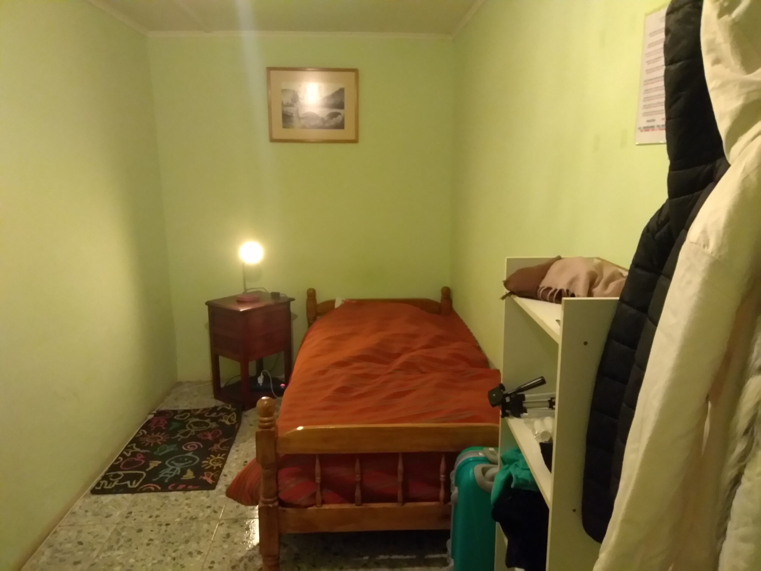 Quarto individual econômico no Sonchek, com cama de solteiro, mesa de cabeceira, abajur e armário