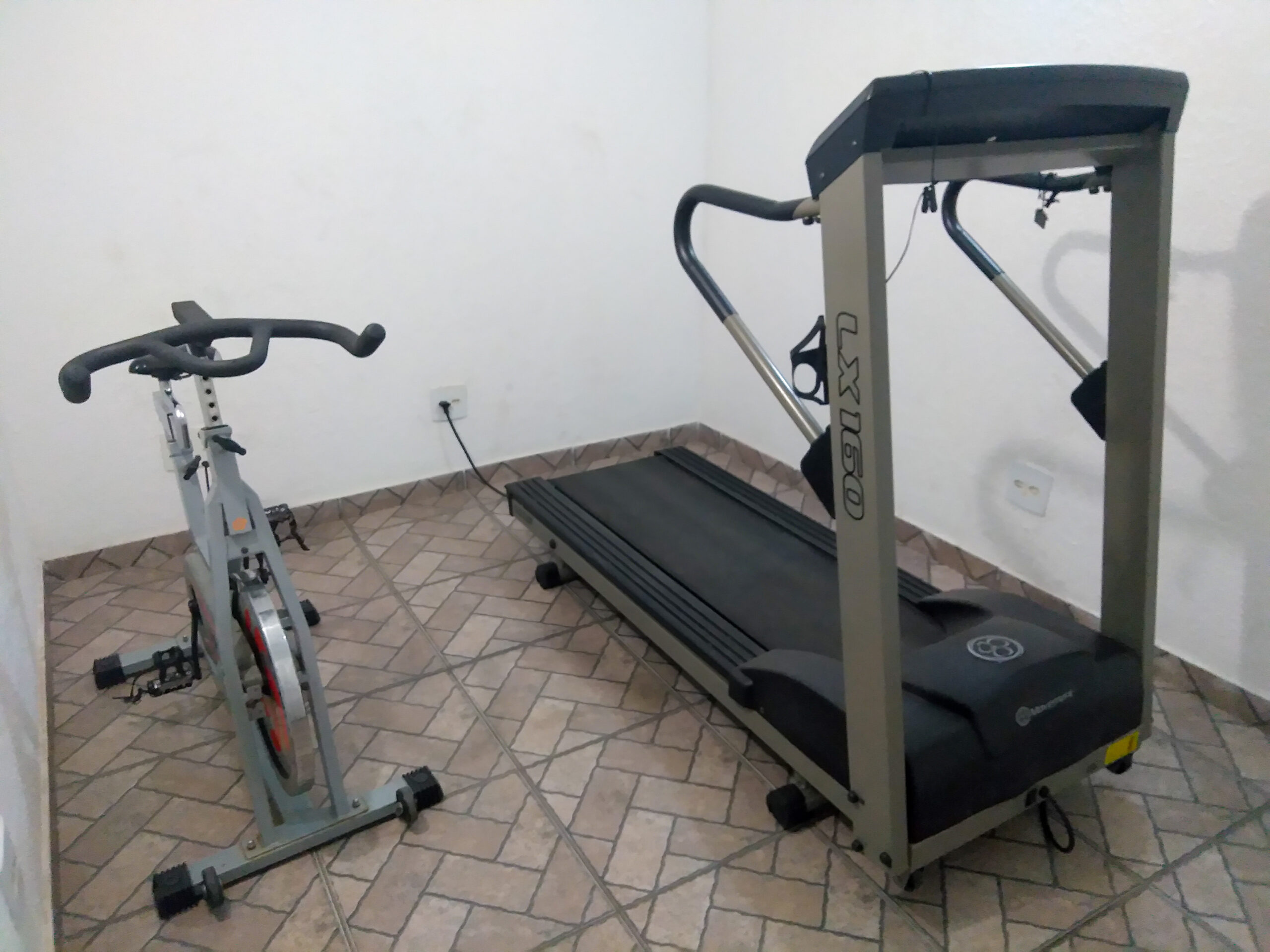 Esteira e bicicleta em pequena academia