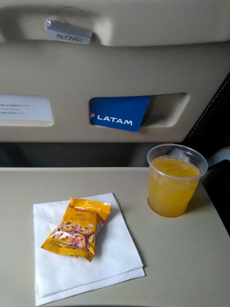 Serviço de bordo no voo da LATAM: bolachas e suco de laranja
