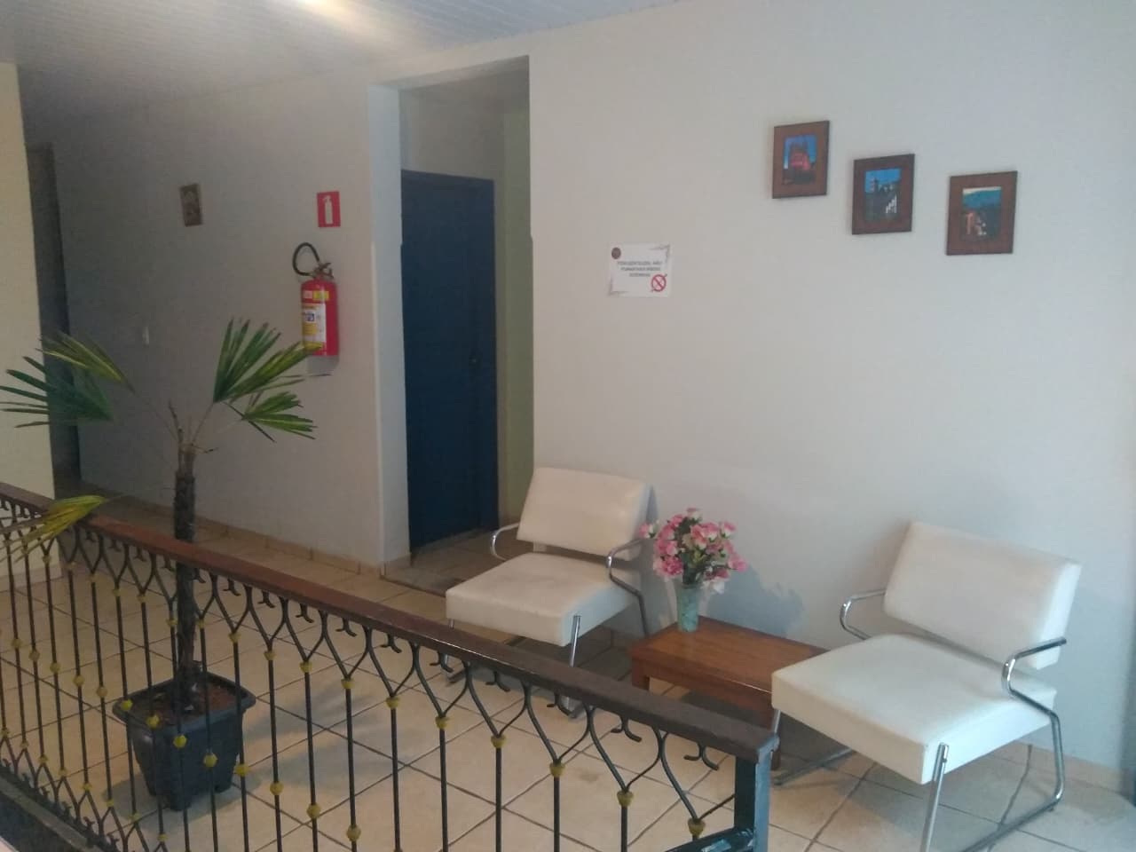 Área comum na Escadaria Vila Rica Pousada & Hostel, com poltronas e mesinha no corredor
