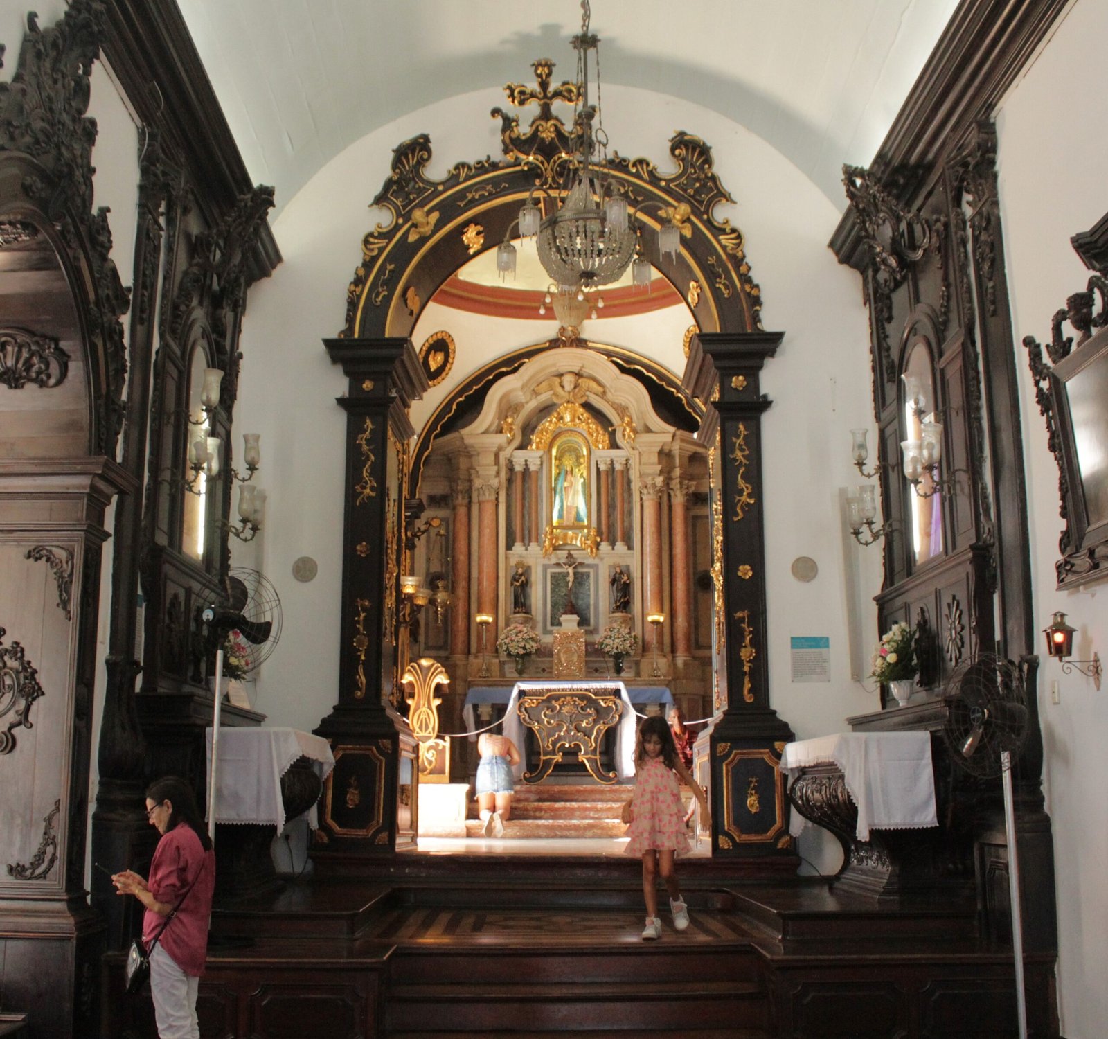 Capela-Mor do Convento da Penha, branda com detalhes em madeira e dourado, com o altar ao fundo